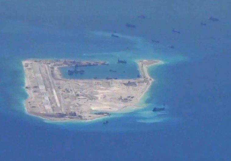 Chinese dredging vessels are purportedly seen in the waters around Fiery Cross Reef in the disputed Spratly Islands in the South China Sea in this still image from video taken by a P-8A Poseidon surveillance aircraft provided by the United States Navy May 21, 2015. 