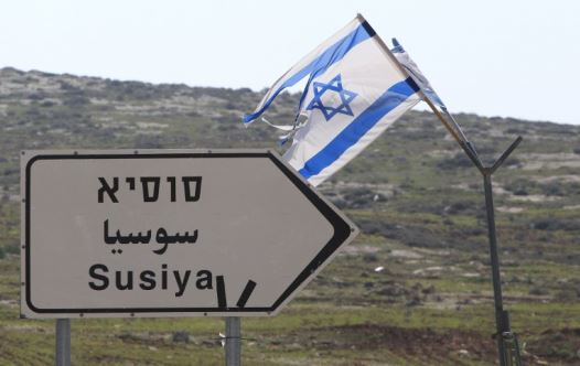 A road sign in English, Hebrew, and Arabic points to the Israeli settlement of Susiya