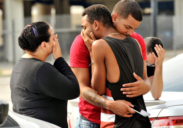 Friends and family members embrace outside the Orlando Police Headquarters during the investigation of a shooting at the Pulse night club, where as many as 20 people have been injured after a gunman opened fire, in Orlando, Florida, US June 12, 2016.