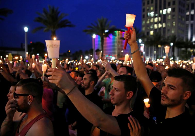 People gather for a candlelight vigil during a memorial service for the victims of the shooting at the Pulse gay nightclub in Orlando, Florida, June 13, 2016