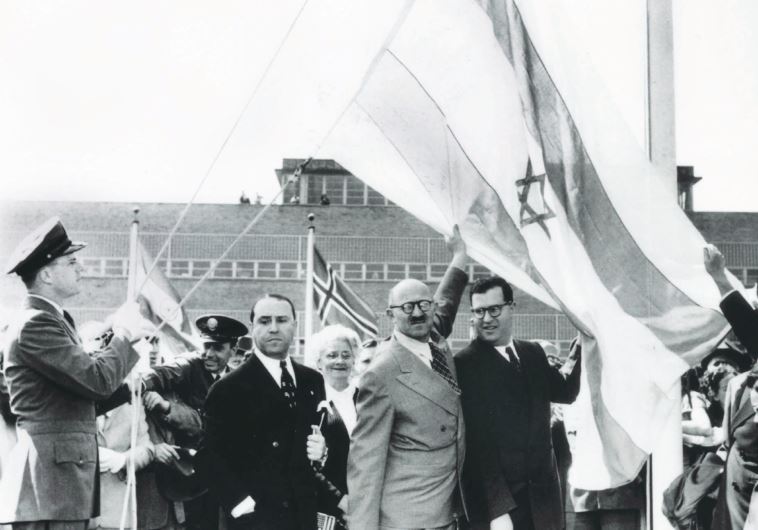 Abba Eban (center right), and David Hacohen (center left) raise the Israeli flag above the UN building on November 29, 1947, soon after the UN voted to partition Palestine