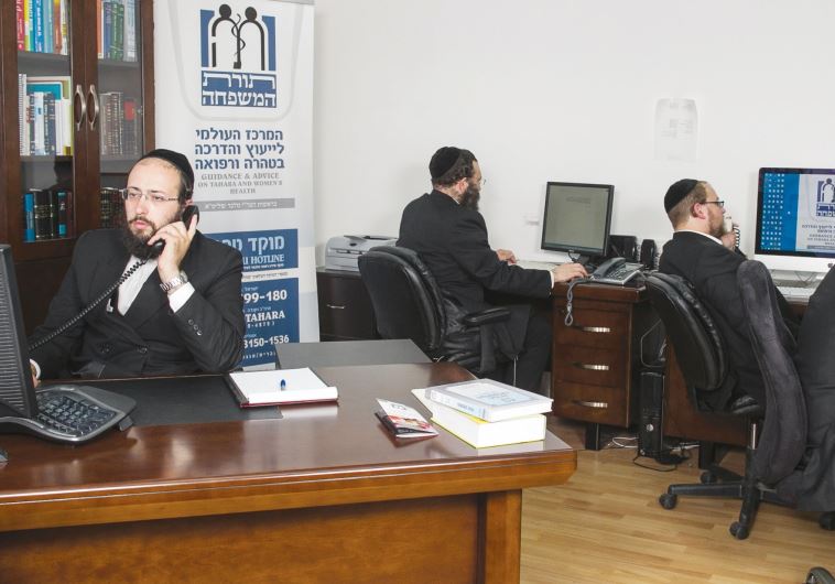 Rabbi Yitzchak Melber (left) and volunteers answer the Tahareinu hotline, fielding questions on Halacha and reproductive health