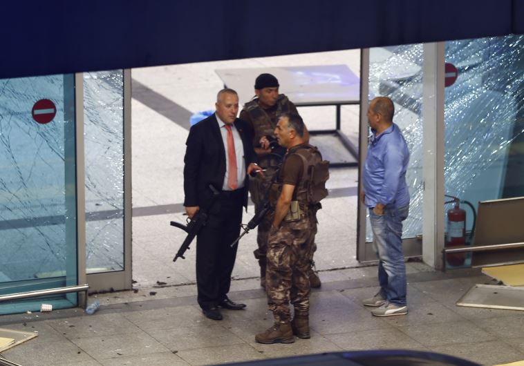 Armed security stand at an entrance of Turkey's largest airport, Istanbul Ataturk, Turkey, following a blast June 28, 2016