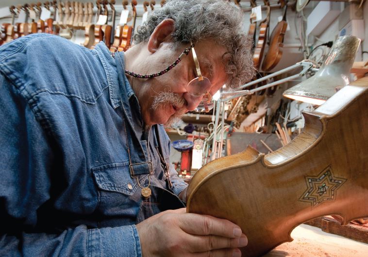 Second-generation violion builder Amnon Weinstein inspects an instrument