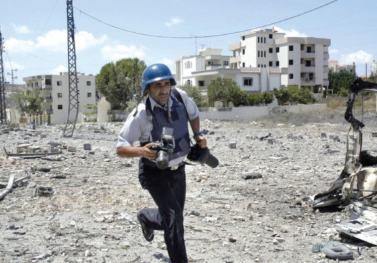 A LEBANESE NEWS PHOTOGRAPHER runs for cover upon hearing Israeli jets above the village of Kfarjouz in 2006.