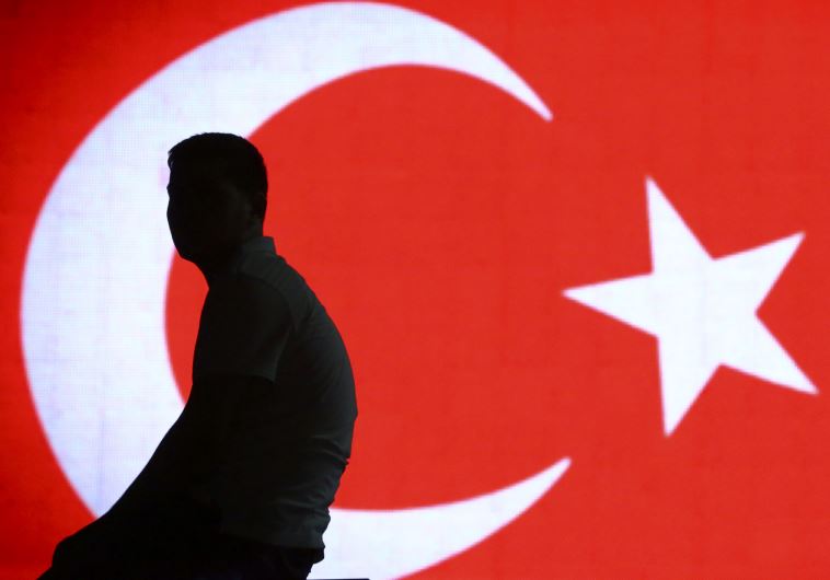 Man sits in front of Turkish flag hours after coup in Turkey thwarted