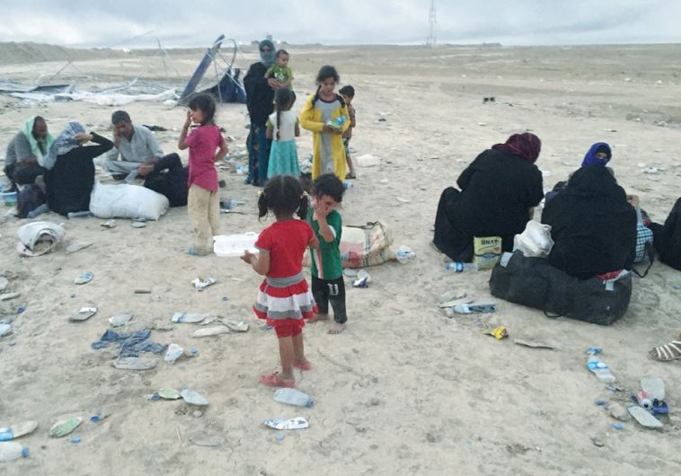 REFUGEES FLEEING from ISIS are seen resting after arriving in Makhmur, Iraq.