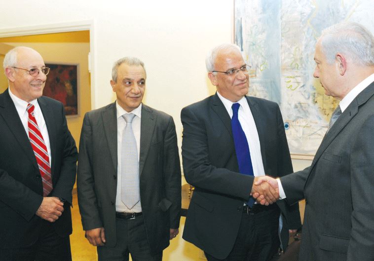 Netanyahu shakes hands with member of the Palestinian Parliament Dr. Saeb Erekat in Jerusalem in April 2012. On the far left side, is Attorney Yitzhak Molcho