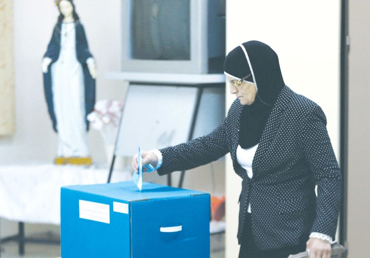 AN ISRAELI ARAB casts her vote at a polling station inside a church in the northern village of Reina on March 17, 2015.