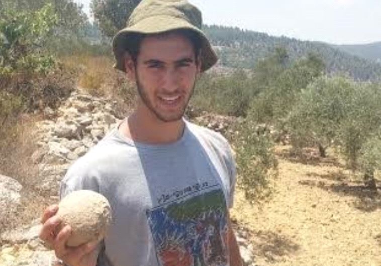 A student from the Kfar Etzion Field School holds a stone ballista ball used during the legendary Bar Kokhba revolt. 