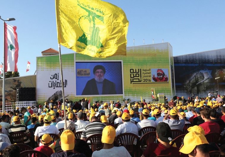 Supporters of Hassan Nasrallah listen to the Hezbollah leader via a screen during a rally marking the 10th anniversary of the end of the 2006 war with Israel, in Bint Jbeil, southern Lebanon, August 13