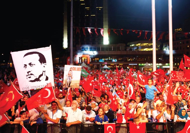SUPPORTERS OF Turkish President Recep Tayyip Erdogan wave national flags in Taksim Square
