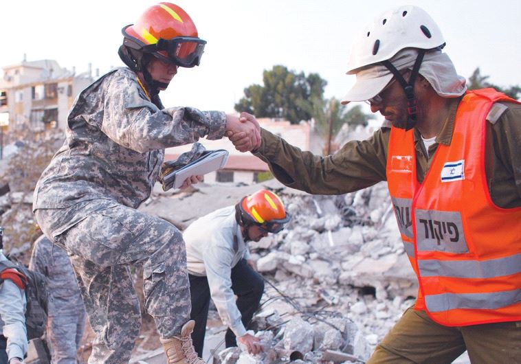 IDF SOLDIERS and US Army observers stand on rubble during an earthquake drill in Holon in October 2012.