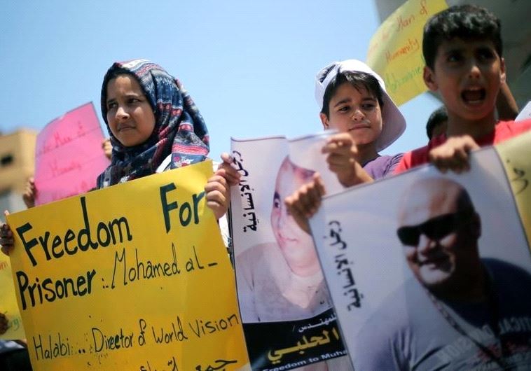 Palestinian demonstrators take part in a protest in solidarity with Mohammad El Halabi, World Vision's manager of operations in Gaza who was accused by Israel of funnelling millions of dollars in aid money to Hamas, organised by foundations and societies benefiting from World Vision in Gaza City Aug