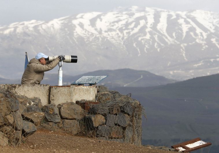A member of the United Nations Disengagement Observer Force (UNDOF) looks through binoculars at Mount Bental, an observation post in the Israeli Golan Heights