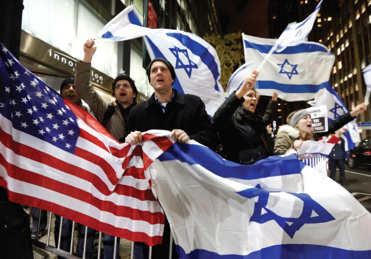 People wave American and Israeli flags‏