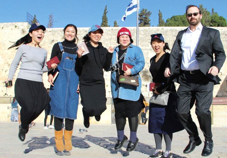 The author jumping in the air in joy at the Western Wall with Jews from China