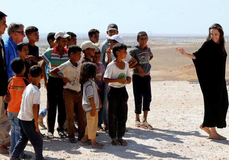 Actress Angelina Jolie (R), speaks to the Syrian refugee children after her news conference at Azraq refugee camp in Jordan