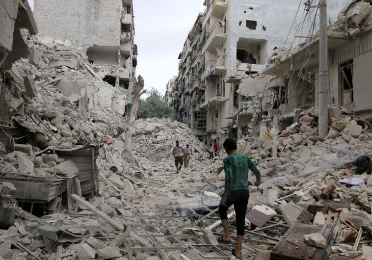 People inspect a damaged site after airstrikes on the rebel held Tariq al-Bab neighbourhood of Aleppo, Syria. 