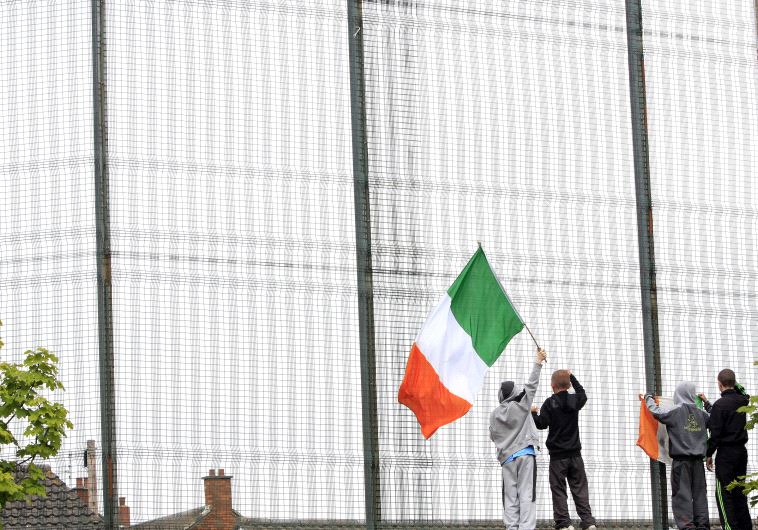 Nationalist youths taunt Loyalists on the opposite side of the peace line as an Orange Parade passed from the Loyalist Shankill Road area of West Belfast through the Nationalist Springfield Road in Belfast.