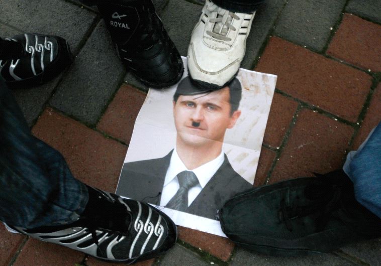 PROTESTERS STEP on a picture depicting Syria’s President Bashar al-Assad as Hitler during a protest in the Galilee town of Kfar Kanna in 2012.