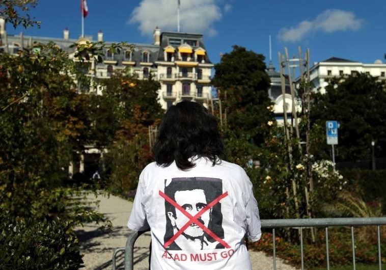 A woman stands outside the Beau-Rivage Palace ahead of Syria talks in Lausanne, Switzerland, October 15, 2016. The T-shirt reads: "Assad must go". 