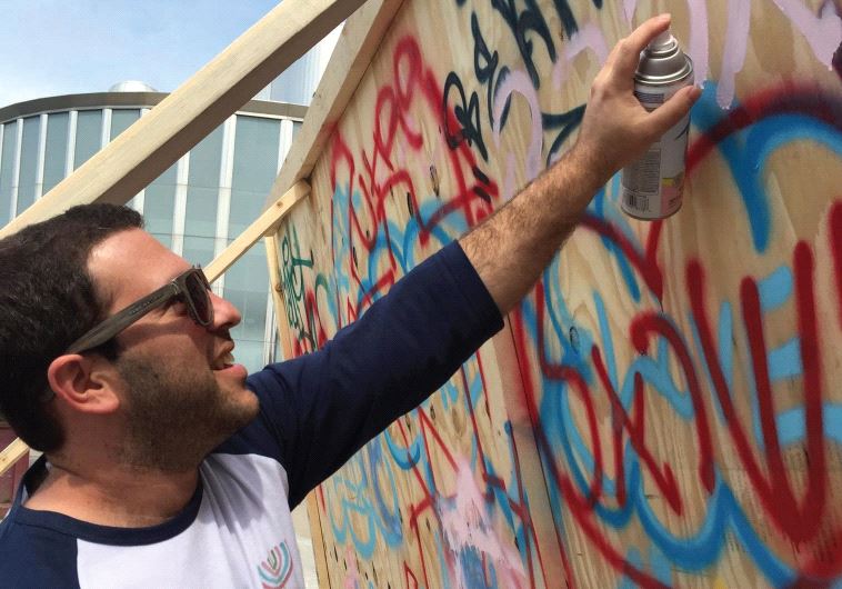 Idan Cohen, a University of Minnesota Hillel Israel Fellow is seen spray painting pro-Israel graffiti on campus