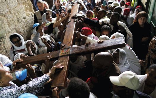 ETHIOPIAN CHRISTIAN worshipers carry a cross during a procession along Via Dolorosa