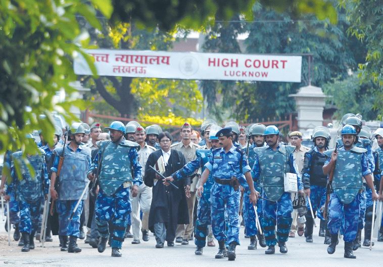 PARAMILITARY SOLDIERS escort the lawyers of Sunni Central Waqf Board and All Babri Masjid Action Committee as they leave the High Court in the northern Indian city of Lucknow in 2010 where they were arguing a case about a disputed mosque built atop a Hindu temple.