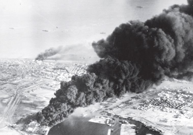 Smoke rises from oil tanks beside the Suez Canal hit during the initial Anglo-French assault on Port Said in November 1956