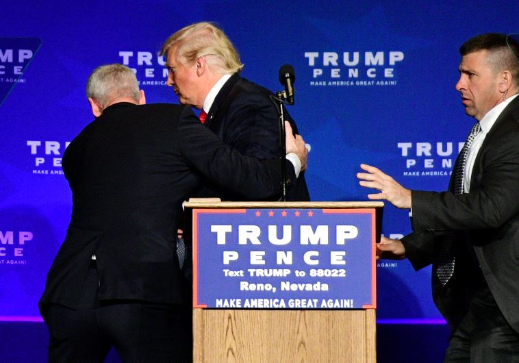 US Republican presidential nominee Donald Trump is hustled off the stage by security agents after a perceived threat in the crowd