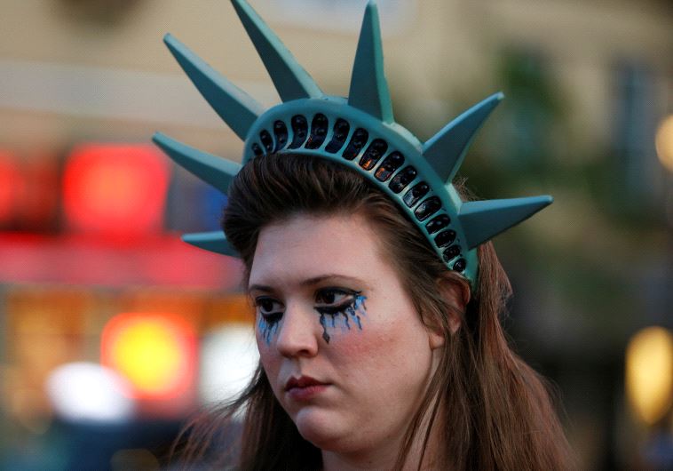 A demonstrator wears a headpiece depicting the crown of the Statue of Liberty during a protest in San Francisco, California, U.S. following the election of Donald Trump as the president of the United States November 9, 2016