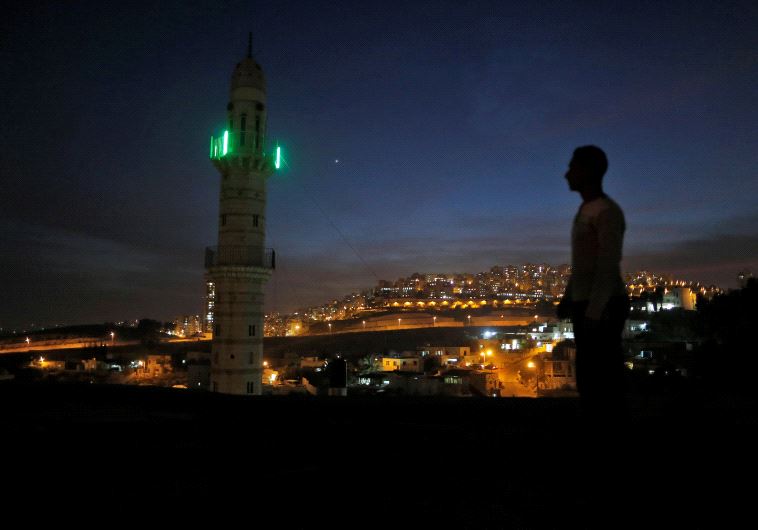 A man stands near a mosque opposite to a neighborhood in east Jerusalem November 13, 2016.