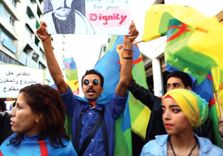 Protesters raise a poster of Riffian Berber hero Abd el-Krim al- Khattabi during a protest, November 6, against the death of a fishmonger in the Moroccan city of Al Hoceima