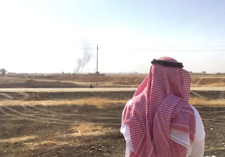 AN ARAB MAN watches the battle for Mosul,