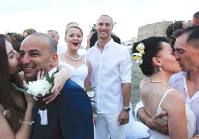 Couples of Russian and Israeli origins kiss during a mass wedding in Larnaca, Cyprus, in June last year
