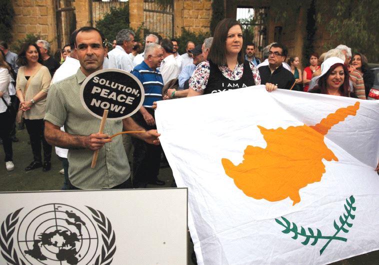 PROTESTORS HOLD a Cyprus flag during a demonstration in favor of a peace settlement on divided Cyprus