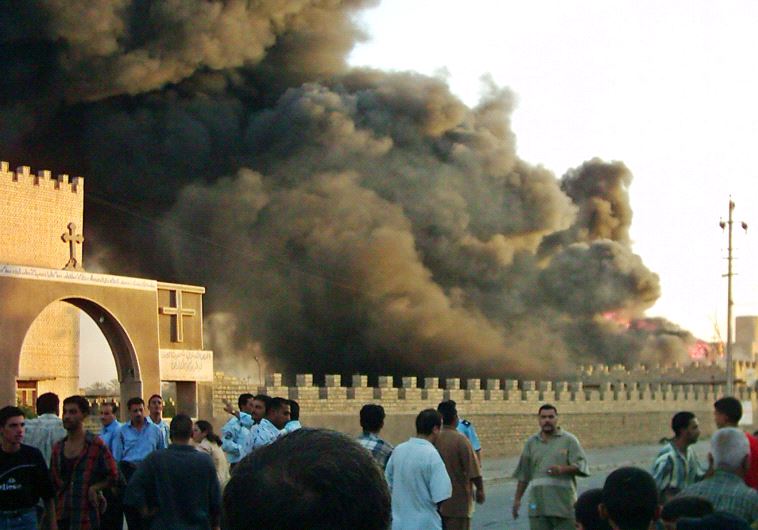 Iraqis crowd the area after an explosion in the car park outside an ancient Chaldean monastery in the Baghdad suburb of Al Doura.