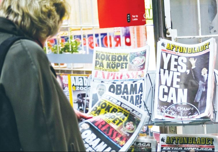 A WOMAN looks at newspapers in Sweden