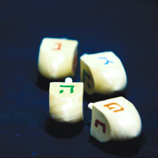 HANUKKA DREIDELS display the letters of the Hebrew acronym for ‘A great miracle happened here.’