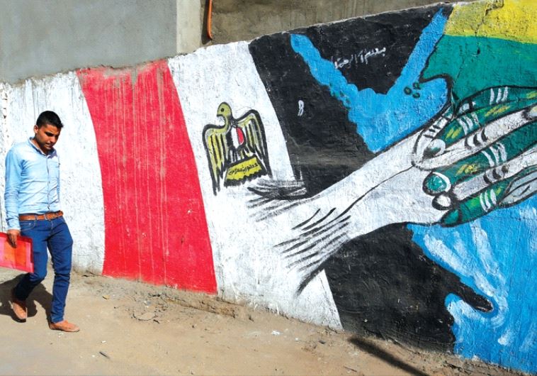 A man walks past graffiti depicting relations between Egypt and Saudi Arabia in Cairo, October 12