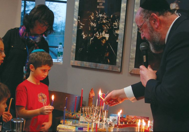 PARTICIPANTS AT Limmud 2016 light Hanukka candles on Monday with British Chief Rabbi Ephraim Mirvis in Birmingham, England