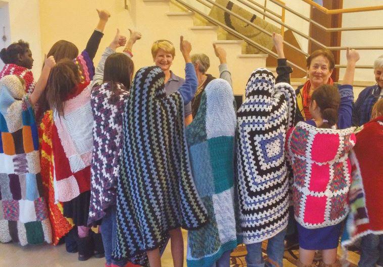 Ashkelon children model the afghans knitted especially for them by ESOA members