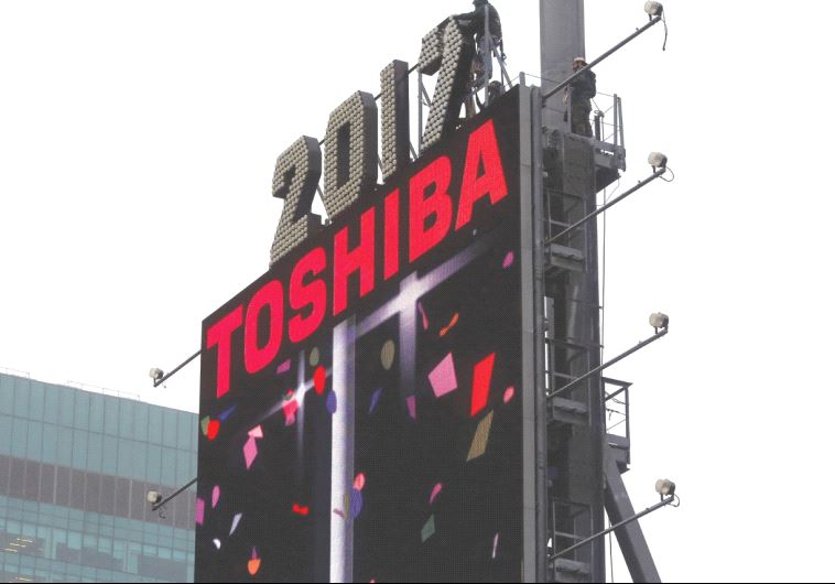 WORKERS PREPARE the New Year’s Eve numerals above a Toshiba sign in Times Square in Manhattan.