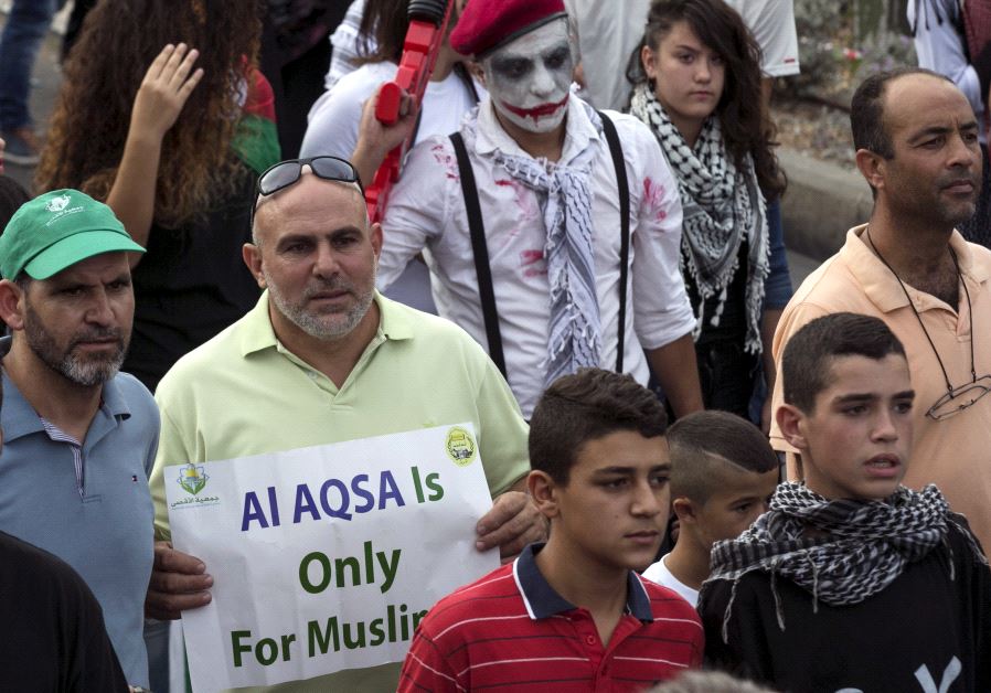 Israeli Arabs take part in a pro-Palestinian rally. One protester holds a sign stating "Al-aqsa [Temple Mount] is Only for Muslims"