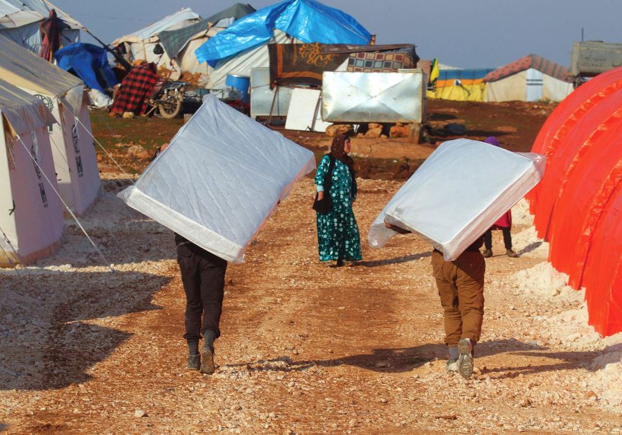 EVACUEES from a rebel-held area of Aleppo carry mattresses they received in the Kamouneh camp in Syria last month