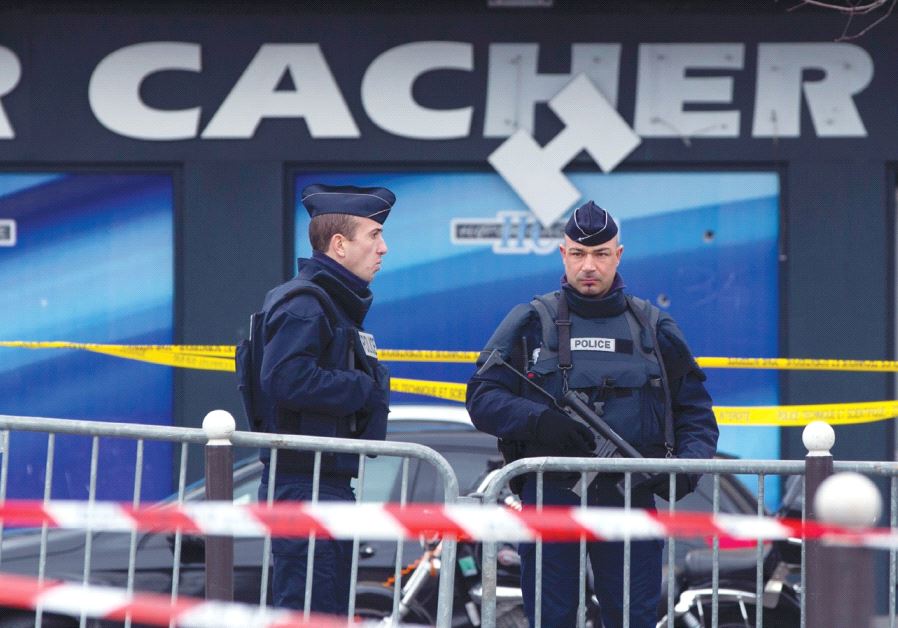 FRENCH POLICE OFFICERS stand guard outside the Hyper Cacher supermarket in Paris on January 10, 2015.