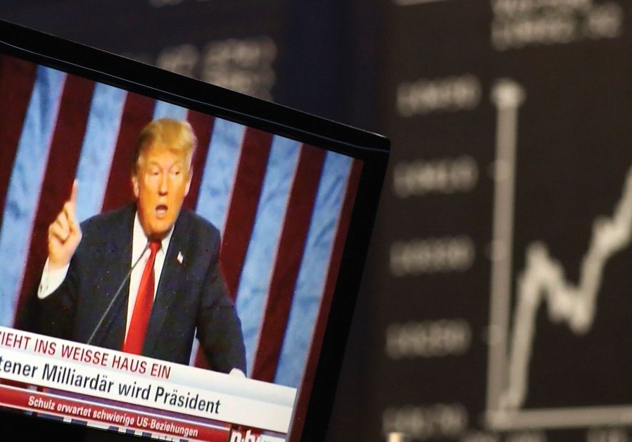 A TV SCREEN showing President-elect Donald Trump is pictured in front of the German share price index, DAX board, at the stock exchange in Frankfurt, Germany, in November