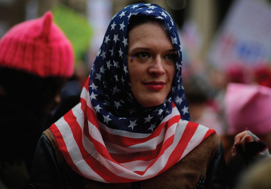 A WOMAN wears a US flag scarf during the Women’s March on Washington, DC, following the inauguration of Donald Trump