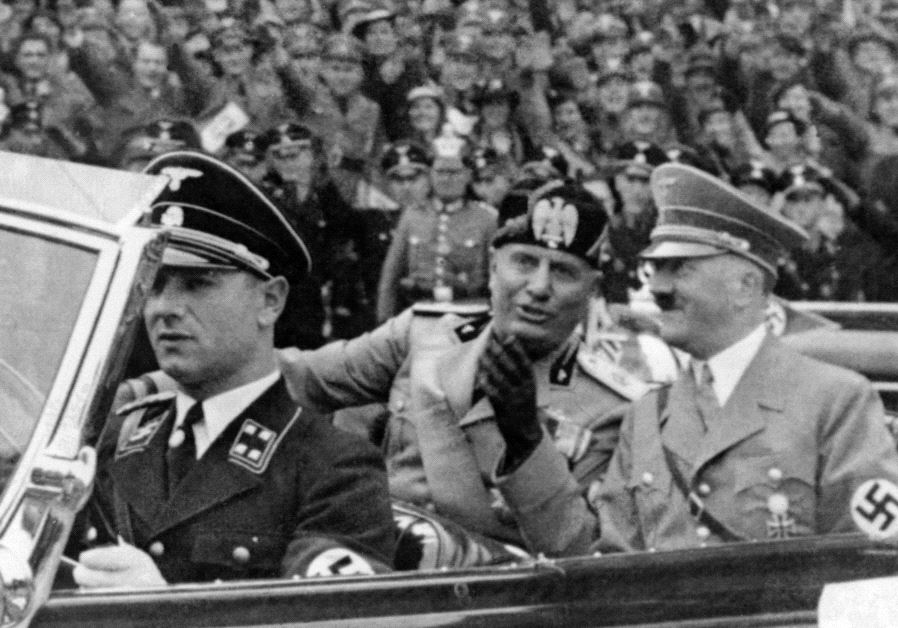 A picture taken in September 1937, in Munich, shows German Chancellor Adolf Hitler (R) riding in a car with Italian dictator Benito Mussolini while the crowd gives the fascist salute.